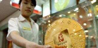 Гігантська олімпійська монета показана публіці